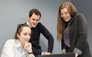 Trois commerciaux en réunion devant un ordinateurs