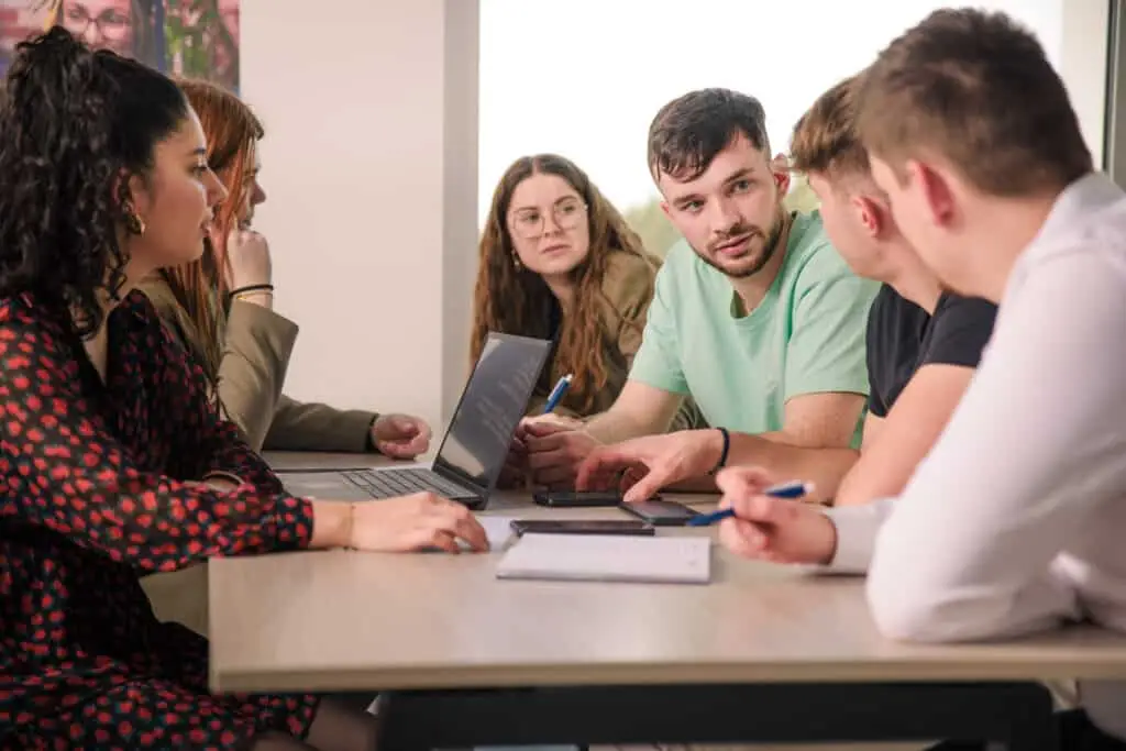 Photo de six étudiants qui discutent et réfléchissent autour d'une table