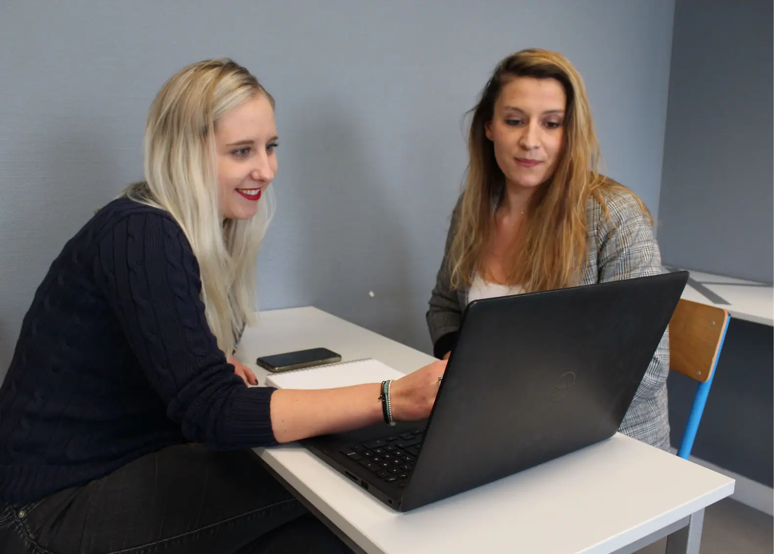 deux salariés Ecofac souriante échangent devant un ordinateur lors d'un entretien