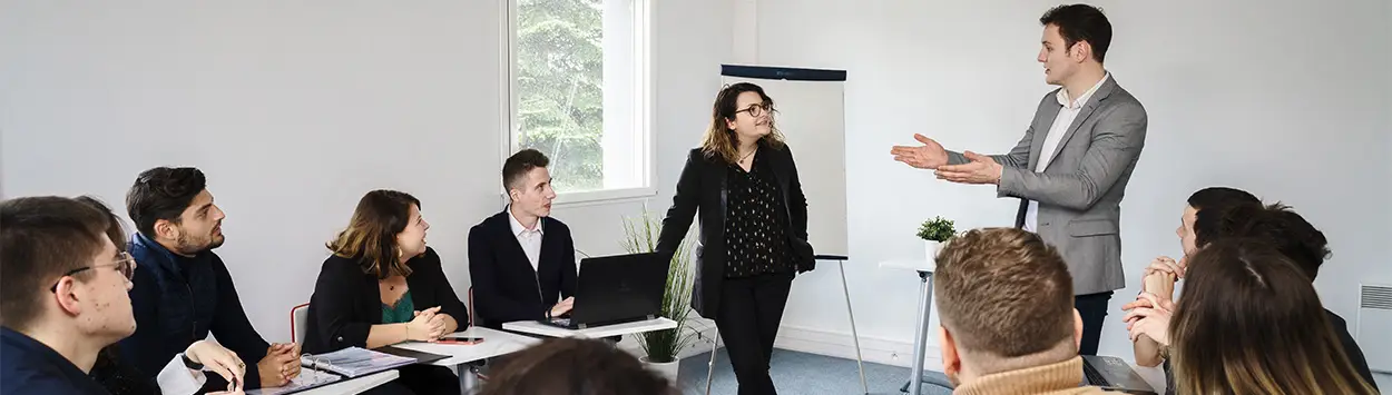 deux apprenant Ecofac Academy présentent leur projet debout face au reste de la promotion