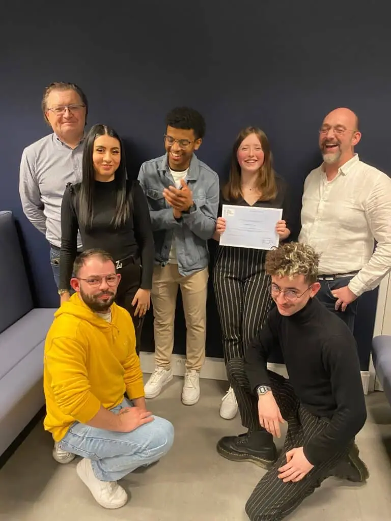 5 apprenants retail posent avec leurs deux formateurs pour la réussite de leur diplôme