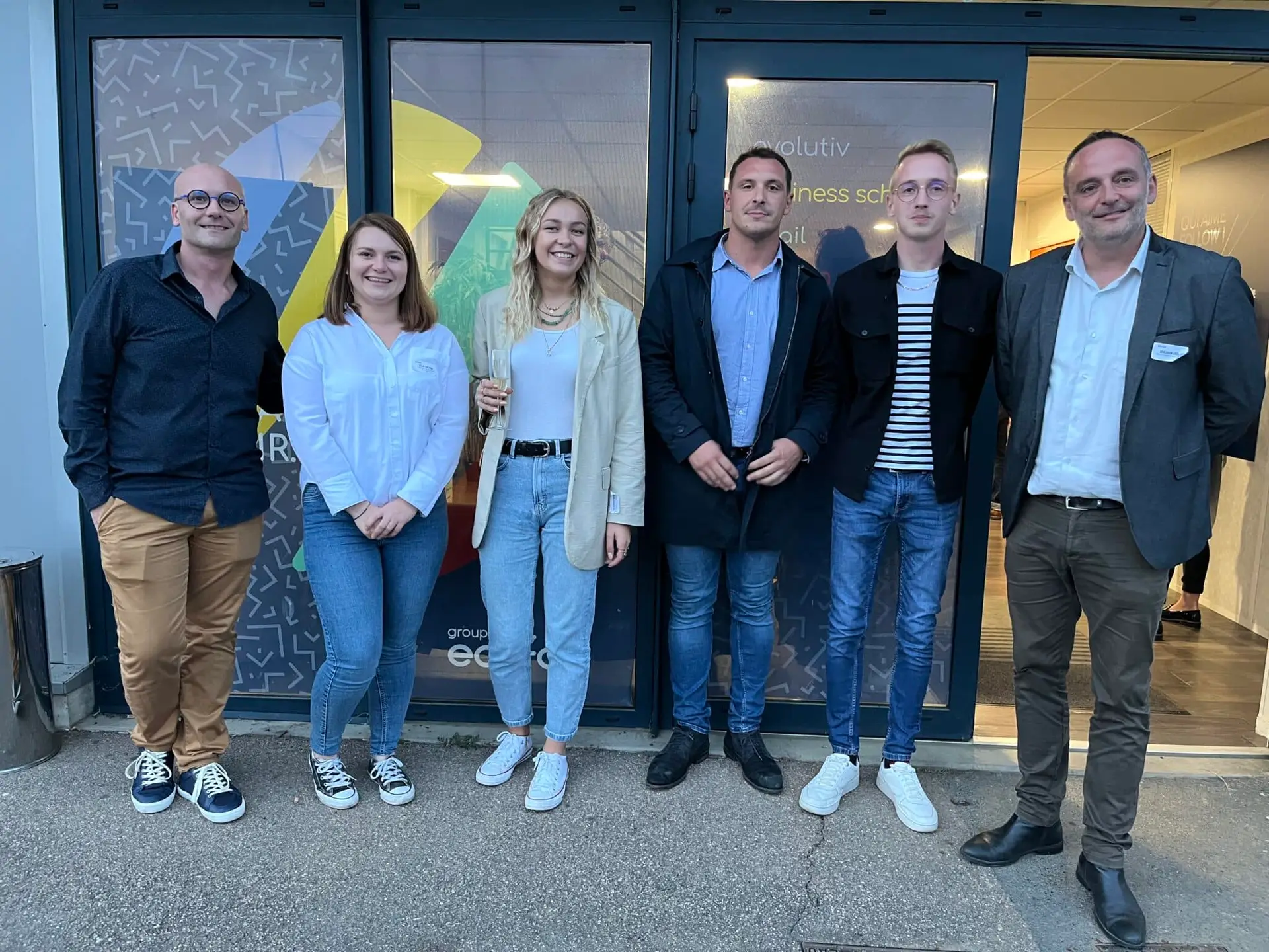 Photo de six collaborateurs du Groupe Ecofac devant l'entrée du campus Ecofac de Caen