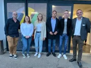 Photo de six collaborateurs du Groupe Ecofac devant l'entrée du campus Ecofac de Caen