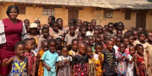 groupe d'enfant d'une école au togo, posant devant l'école dans le cadre d'une distribution de jouer et de matériel scolaire