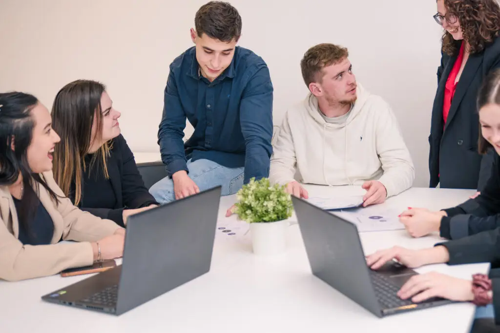 Photo de six étudiants travaillant sur deux ordinateurs autour d'une table