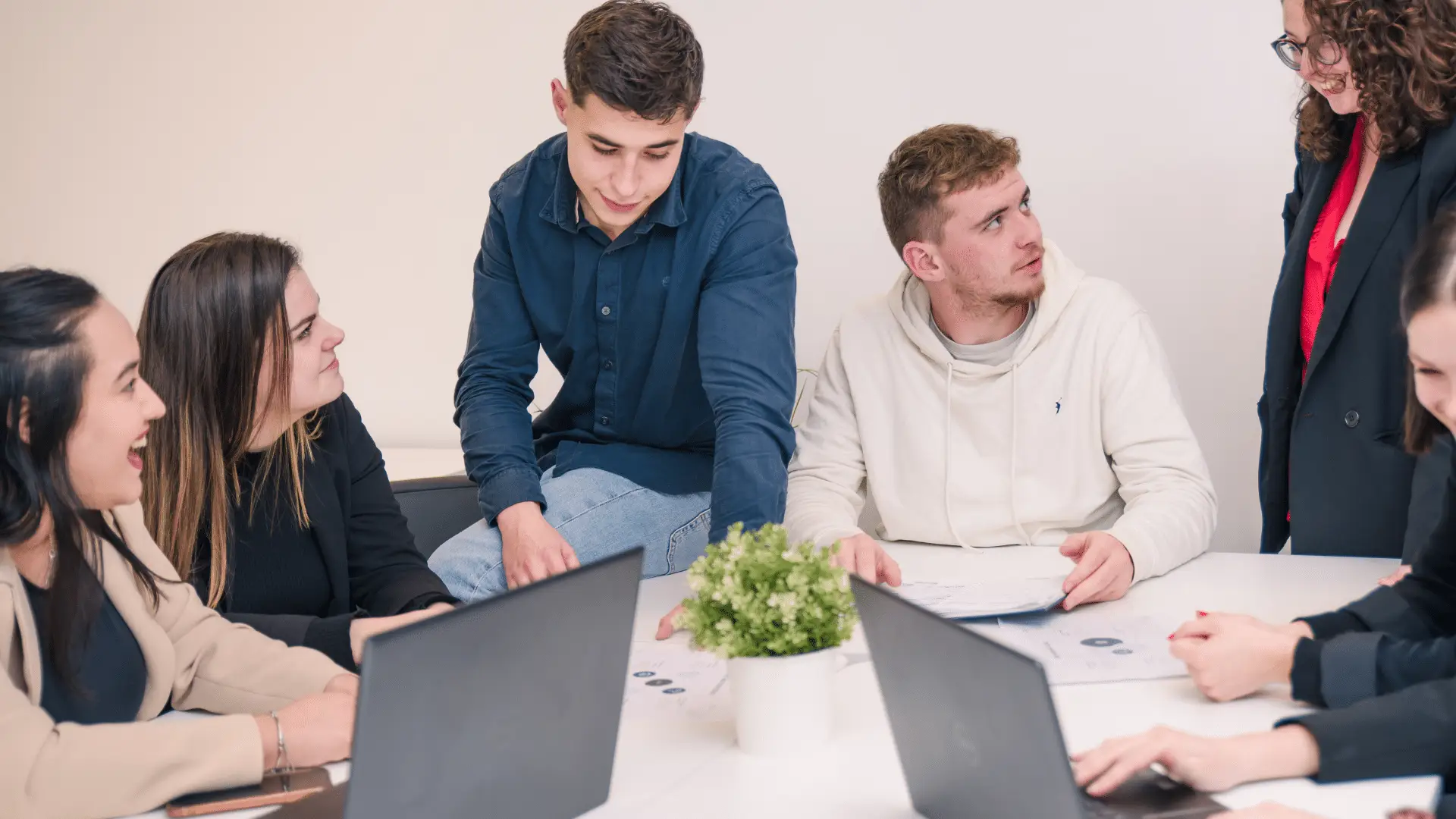 5 étudiants échangent autour d'une table lors d'un projet de groupe