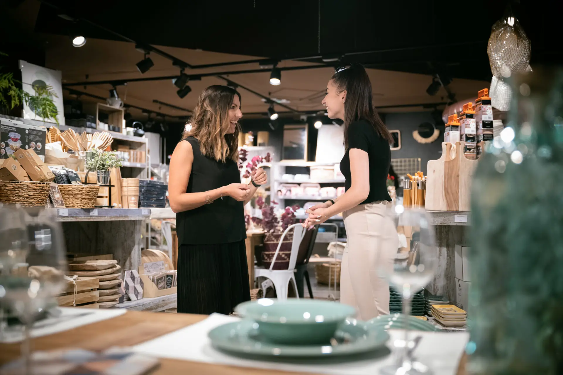 apprenante retail qui discute avec sa tutrice au milieu de son magasin de décoration