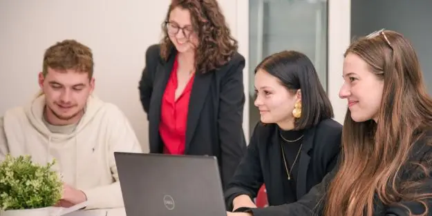 groupe d'étudiants qui échangent sur leur ordinateur au campus