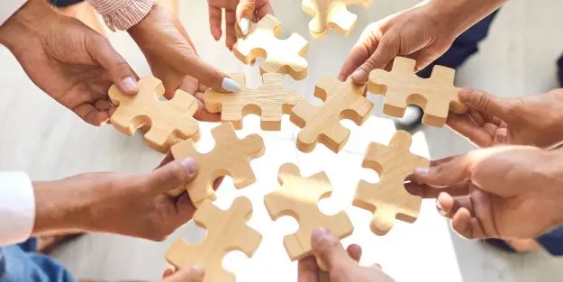 des mains forment un puzzle pour représenter la coopération
