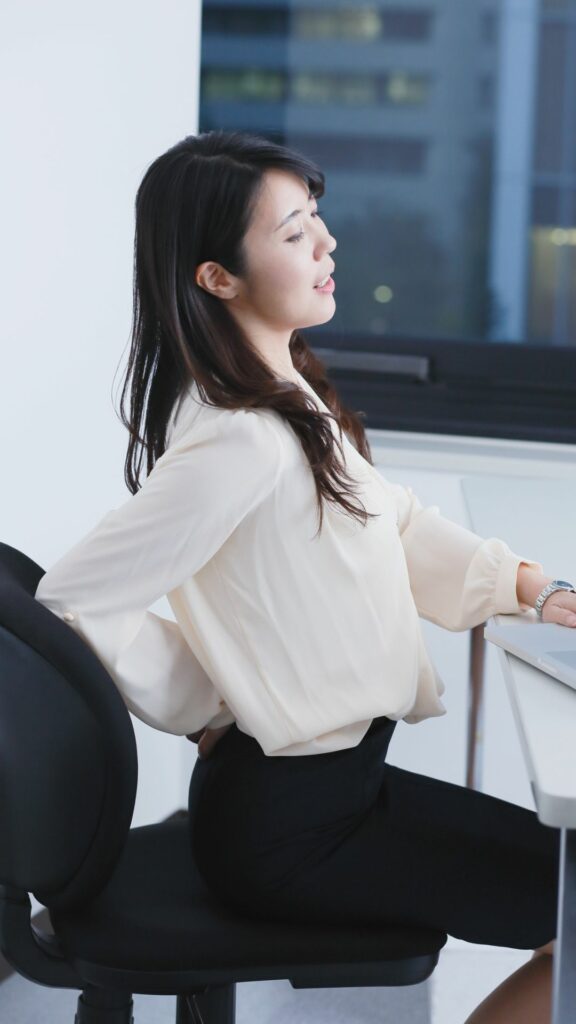 jeune femme qui à mal au dos sur son poste de travail